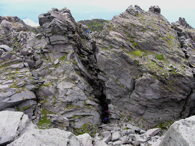 複雑な溶岩ドームの合間を歩く登山者